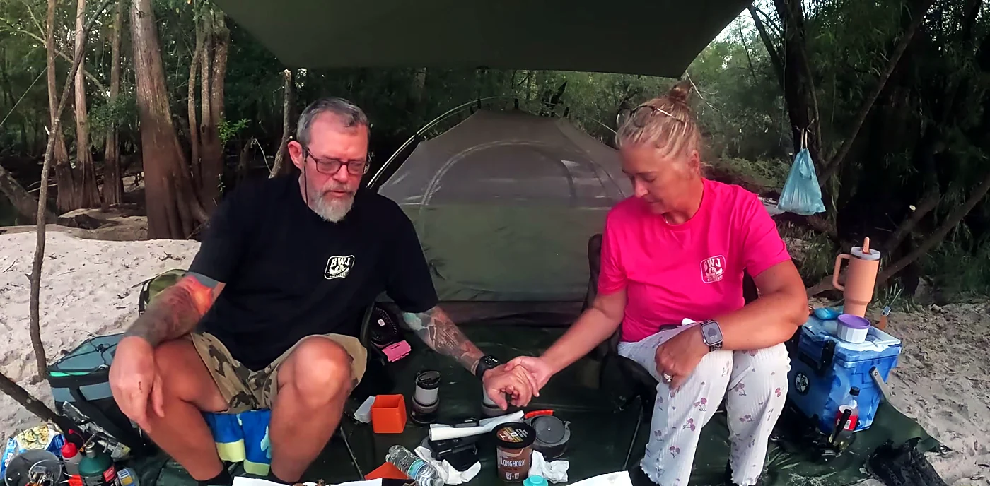 Rodney and Tina saying the blessing over supper under a tarp on a Satilla River sandbar